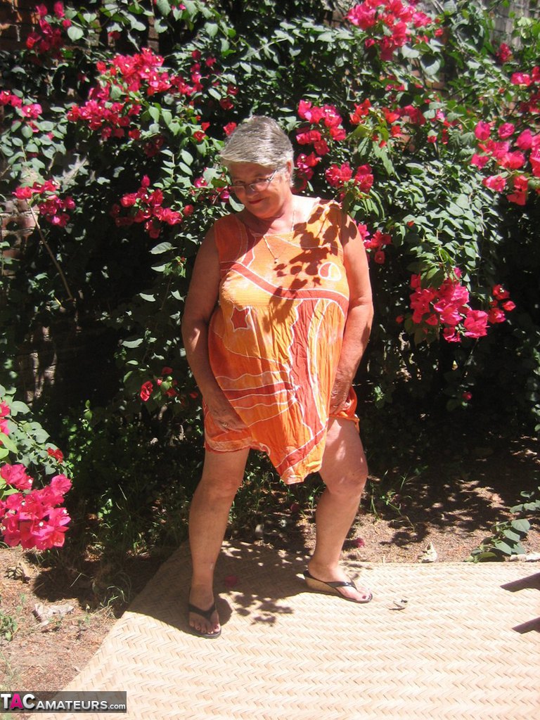 Obese granny Girdle Goddess strips to her sandals on garden patio  